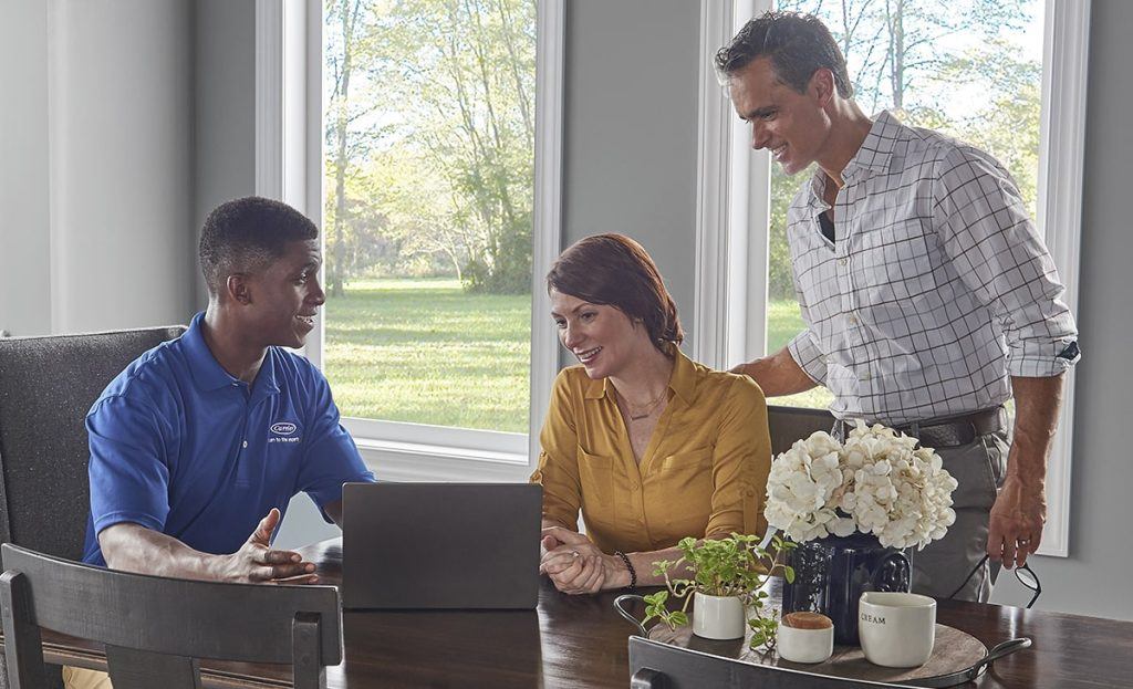 Dealer With Couple At Dining Table Laptop