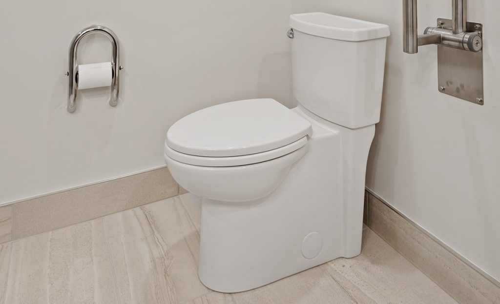 White Toilet In Bathroom With Roll Of Toilet Paper